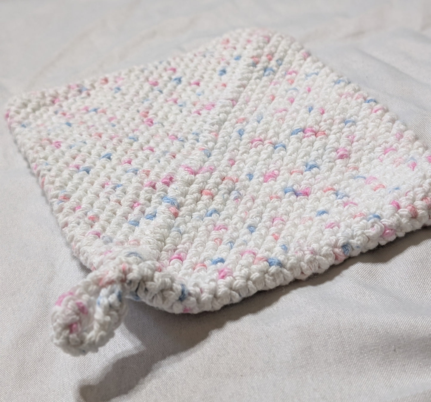 White pink blue speckled hot pad