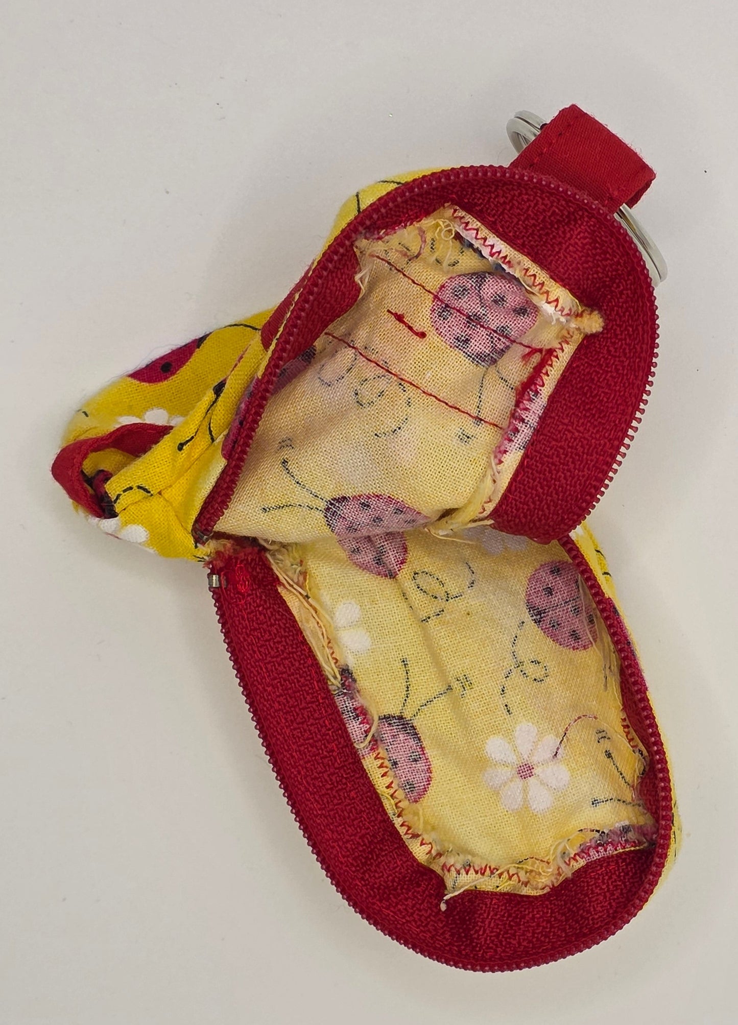 fabric mini backpack pouch with ladybug pattern on a light gray background