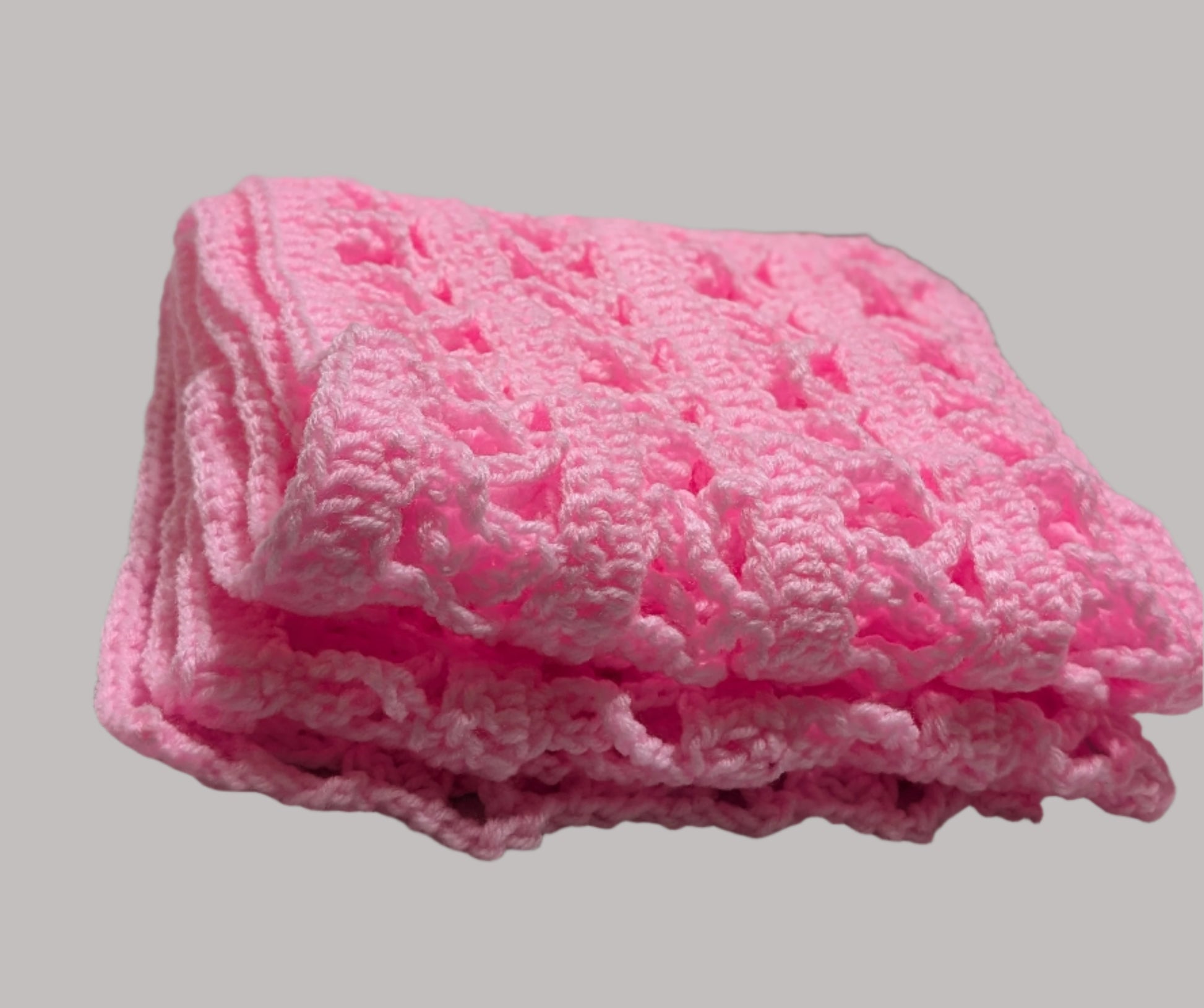 crocheted pink scarf with a breast cancer symbol on a white surface